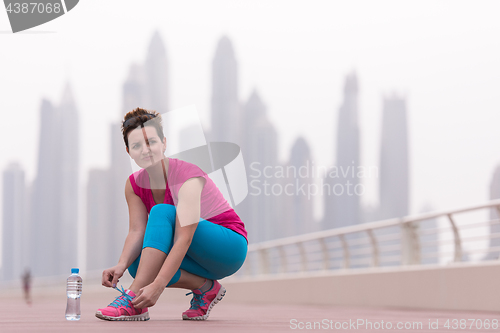 Image of woman tying shoelaces on sneakers