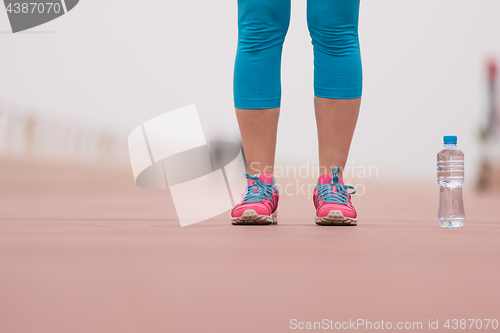 Image of close up on running shoes and bottle of water