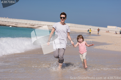 Image of mother and daughter running on the beach