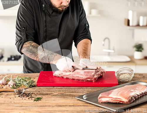 Image of Man cooking meat steak on kitchen