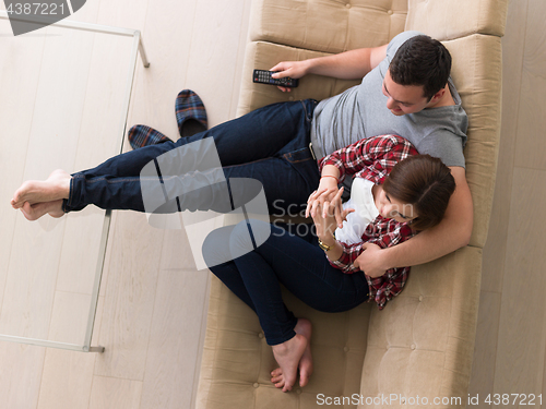 Image of Young couple on the sofa watching television