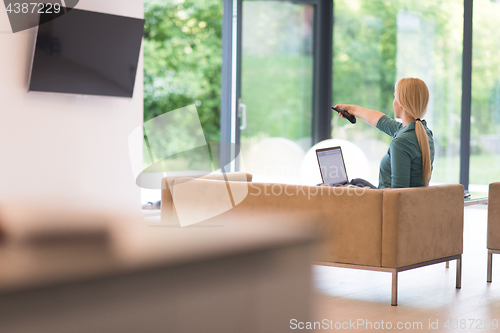 Image of Young woman using laptop at home