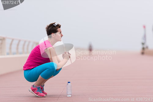 Image of woman stretching and warming up on the promenade