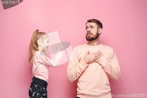 Image of Young father with his baby daughter. The kid in preschool age pointing with finger