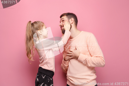 Image of Young father with his baby daughter. The kid in preschool age pointing with finger