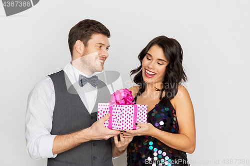 Image of happy couple with gift box at birthday party