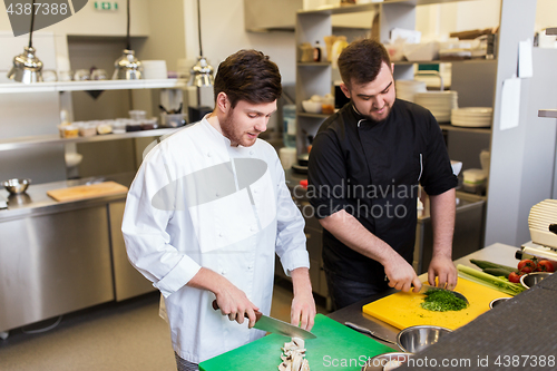 Image of chef and cook cooking food at restaurant kitchen