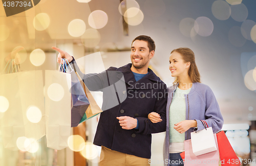 Image of happy young couple with shopping bags in mall