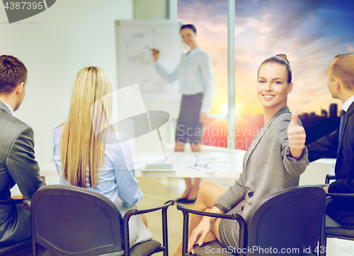 Image of businesswoman showing thumbs up at office