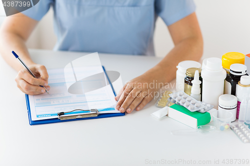 Image of doctor with medicines and clipboard at hospital