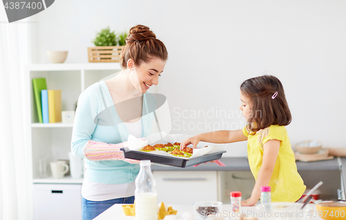 Image of mother and daughter baking muffins at home