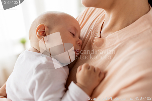 Image of close up of mother holding sleeping baby