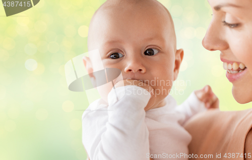 Image of happy mother with little baby boy sucking fingers