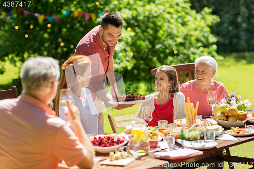 Image of happy family having dinner or summer garden party