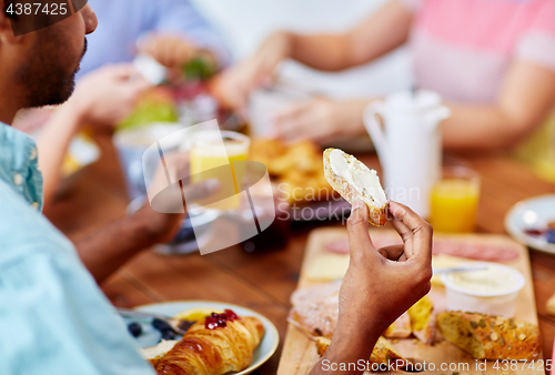 Image of close up of man eating toast with cream cheese