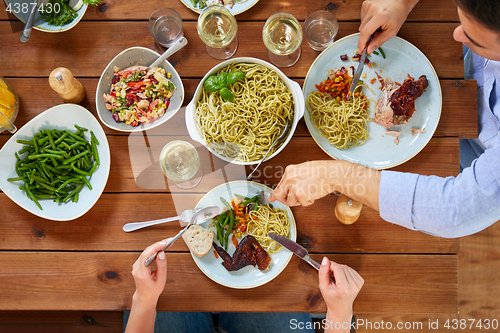 Image of couple at table with food eating pasta and chicken