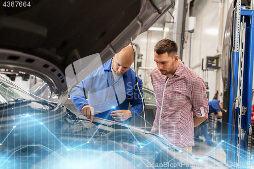 Image of auto mechanic with clipboard and man at car shop