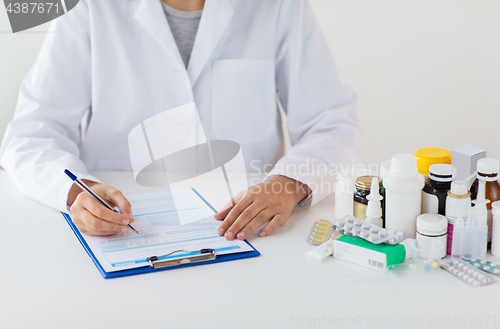 Image of doctor with medicines and clipboard at hospital