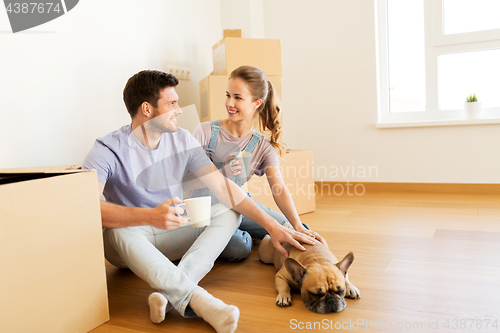 Image of happy couple with boxes and dog moving to new home