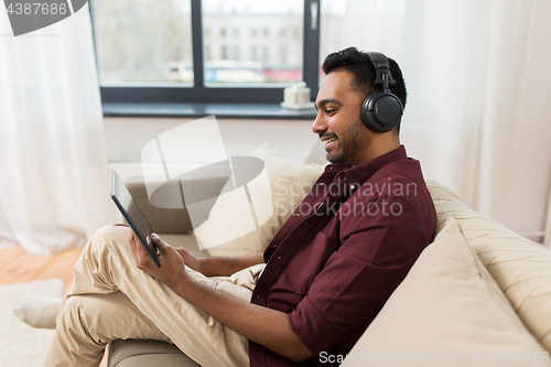 Image of man in phones with tablet pc listening to music