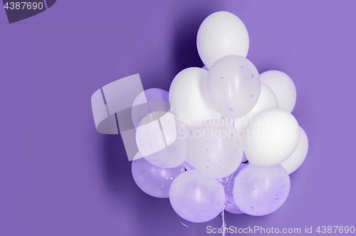 Image of white helium balloons on ultra violet background