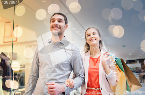 Image of happy young couple with shopping bags in mall