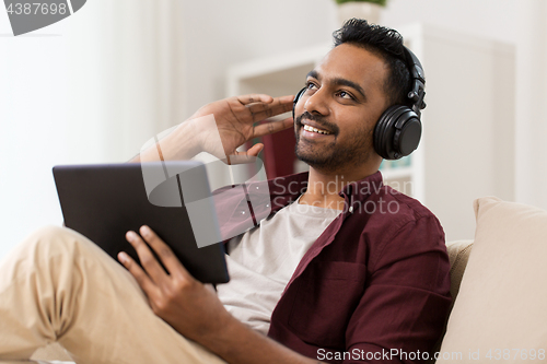 Image of man in phones with tablet pc listening to music