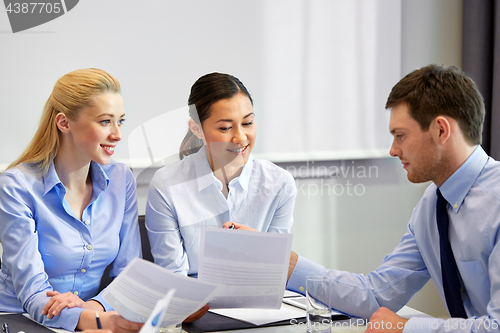 Image of happy business team with papers at office