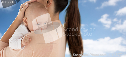 Image of close up of little baby boy with mother over sky