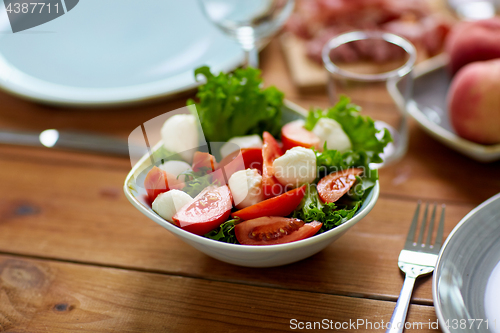 Image of vegetable salad with mozzarella on wooden table