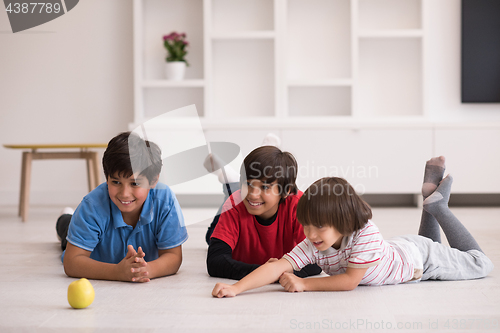 Image of boys having fun with an apple on the floor