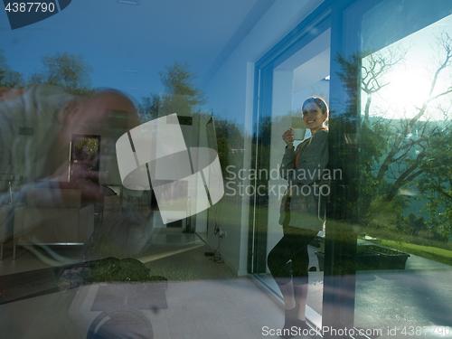 Image of woman drinking coffee in front of her luxury home villa