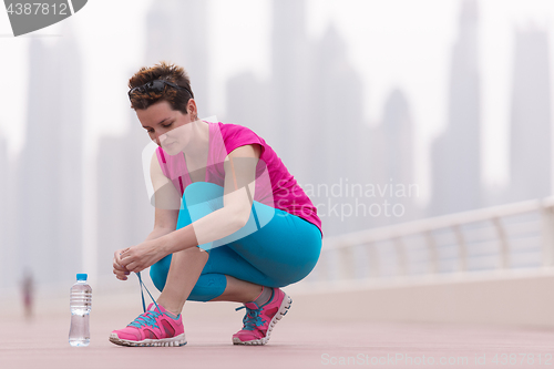 Image of woman tying shoelaces on sneakers