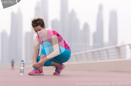 Image of woman tying shoelaces on sneakers