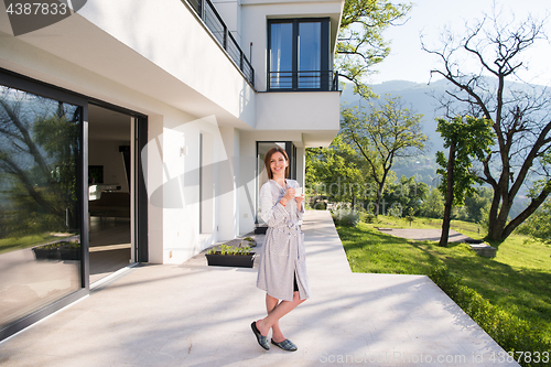 Image of woman in a bathrobe enjoying morning coffee