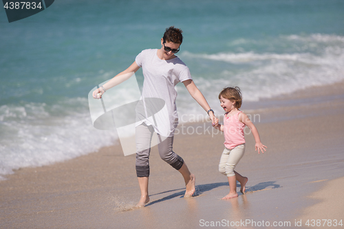 Image of mother and daughter running on the beach