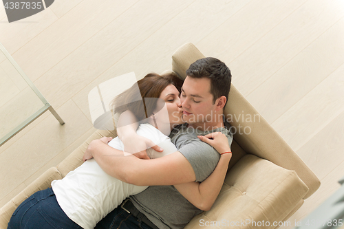 Image of young handsome couple hugging on the sofa