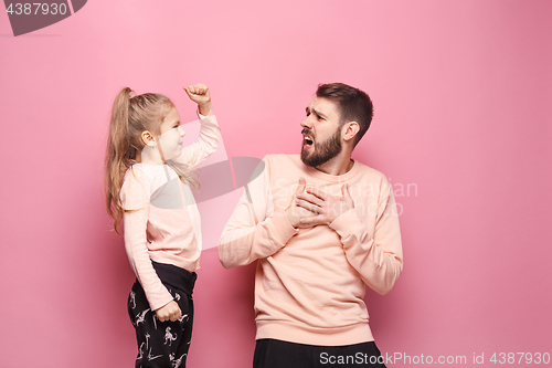 Image of Young father with his baby daughter. The kid in preschool age pointing with finger