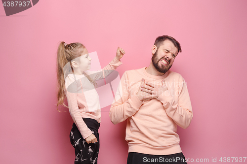 Image of Young father with his baby daughter. The kid in preschool age pointing with finger