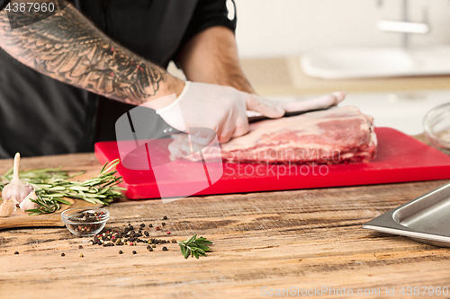 Image of Man cooking meat steak on kitchen