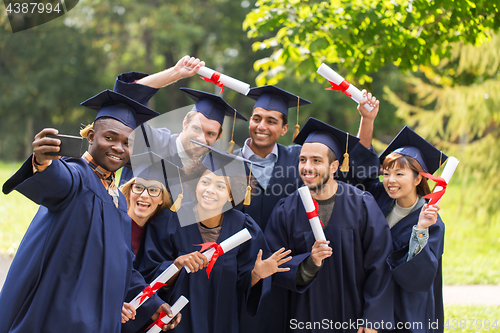 Image of students or graduates with diplomas taking selfie