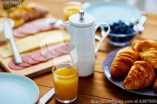 Image of coffee pot, juice and food on table at breakfast