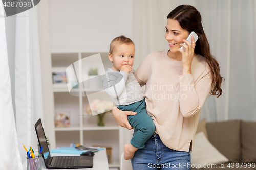 Image of mother with baby calling on smartphone at home