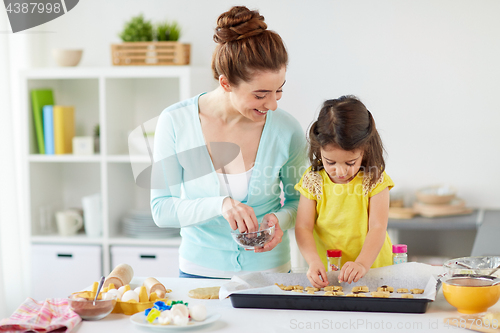 Image of happy mother and daughter making cookies at home