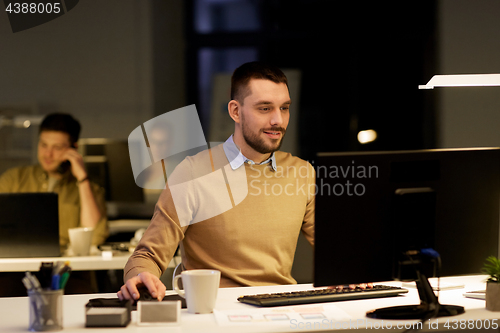 Image of man with computer working late at night office