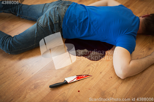 Image of dead man body lying on floor at crime scene