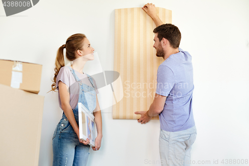 Image of couple with wallpaper repairing apartment or home