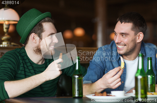 Image of happy male friends drinking beer at bar or pub