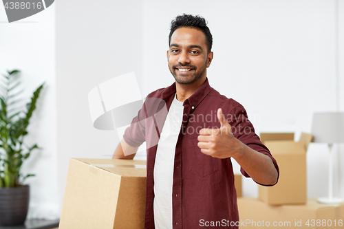 Image of man with box moving to new home showing thumbs up