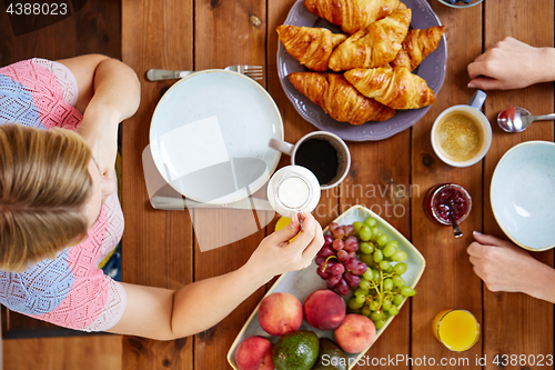 Image of woman with cream and coffee having breakfast